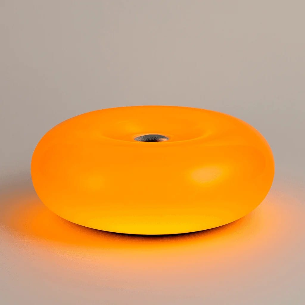 Glowing warm orange donut lamp sitting on a wooden side table near a sofa