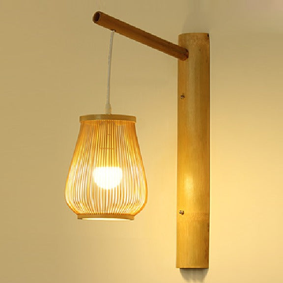 A Japanese style wall lamp with a handwoven bamboo pendant shade hanging from a wooden arm.