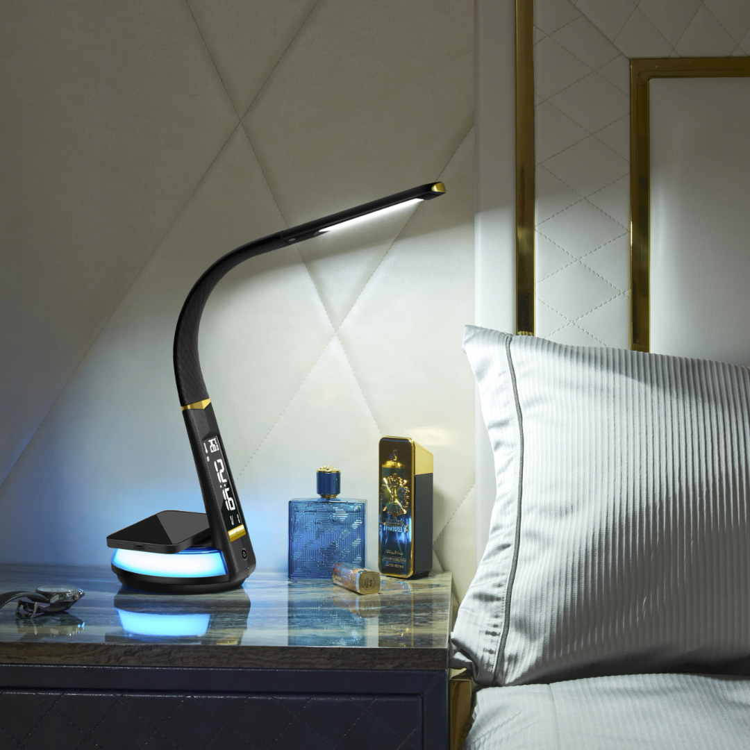A black flexible desk lamp with a digital display and wireless charging base on a white nightstand.
