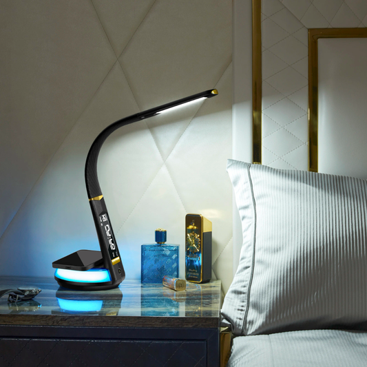 A black flexible desk lamp with a digital display and wireless charging base on a white nightstand.