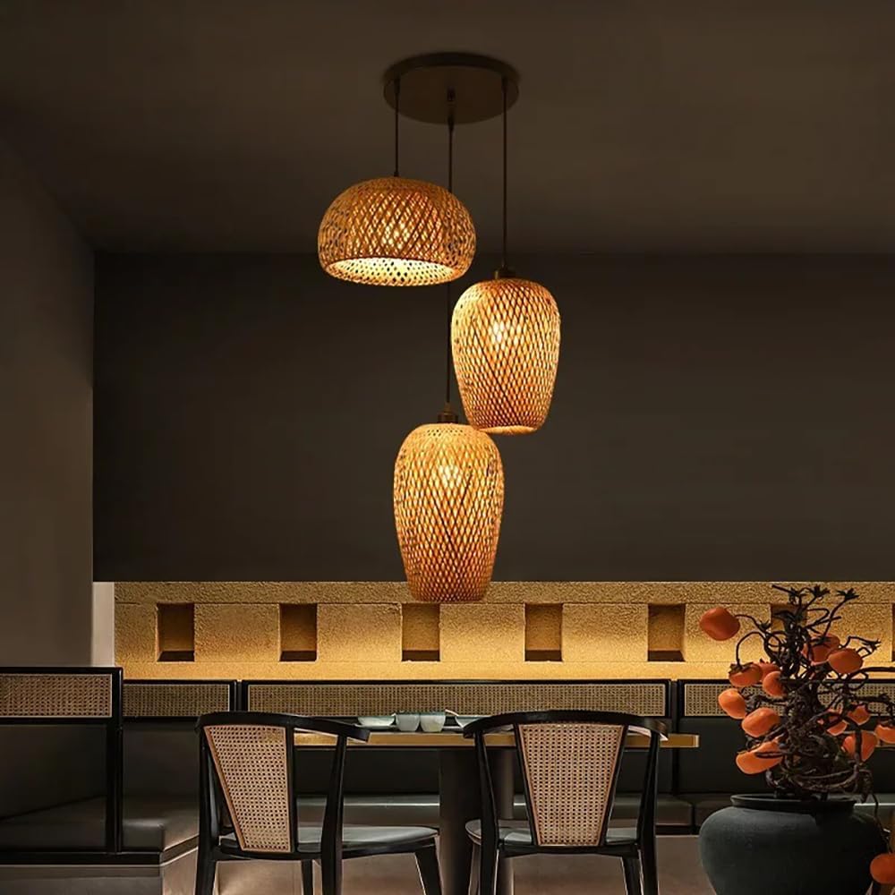 Three staggered woven bamboo pendant lights hanging over a dining table in a warm, dimly lit room.