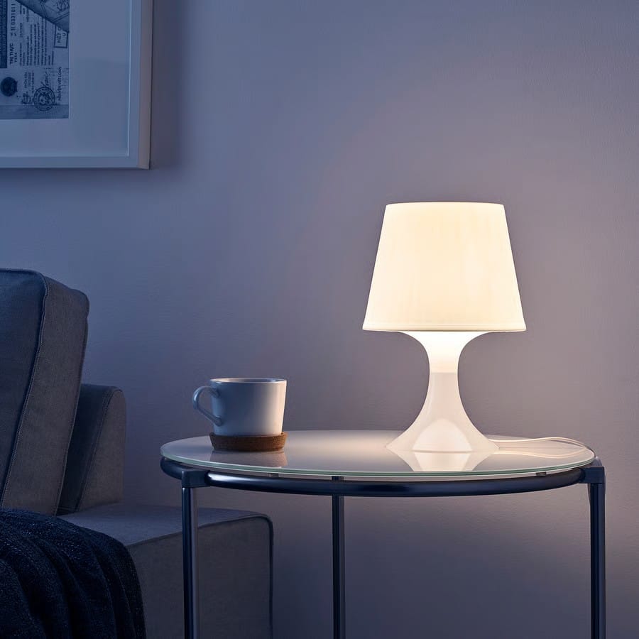 Lamp and cup on a table in a dimly lit room