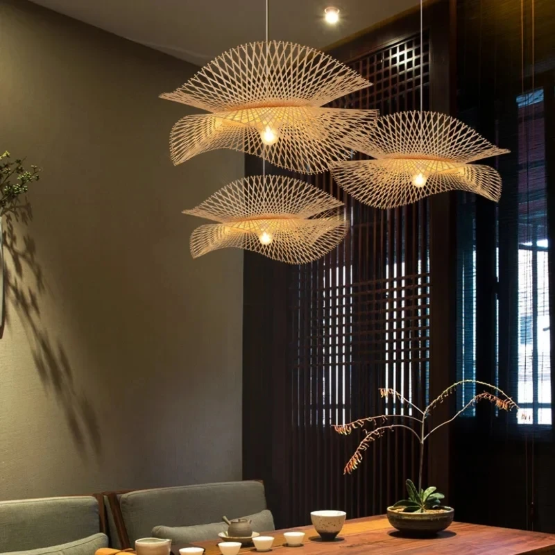 wave-shaped bamboo pendant lights hanging over a wooden dining table in a dimly lit room.